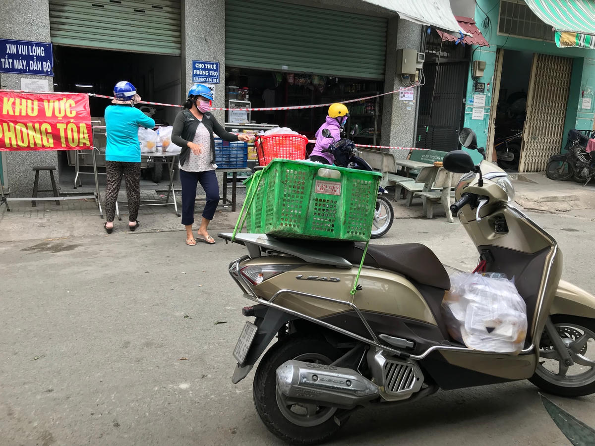 chiếc xe của mình chở các phần cơm tới địa điểm phong toả để phân phát cho người dân.