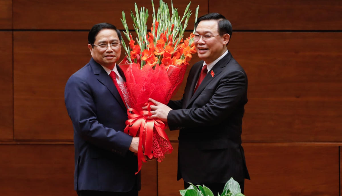 Chủ tịch Quốc hội Vương Đình Huệ tặng hoa Thủ tướng Phạm Minh Chính. Ảnh: Quang Vinh.