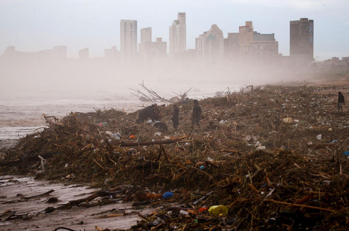 Mọi người tìm kiếm những món đồ có thể vớt được trên bãi biển ở Durban. Ảnh: CNN.
