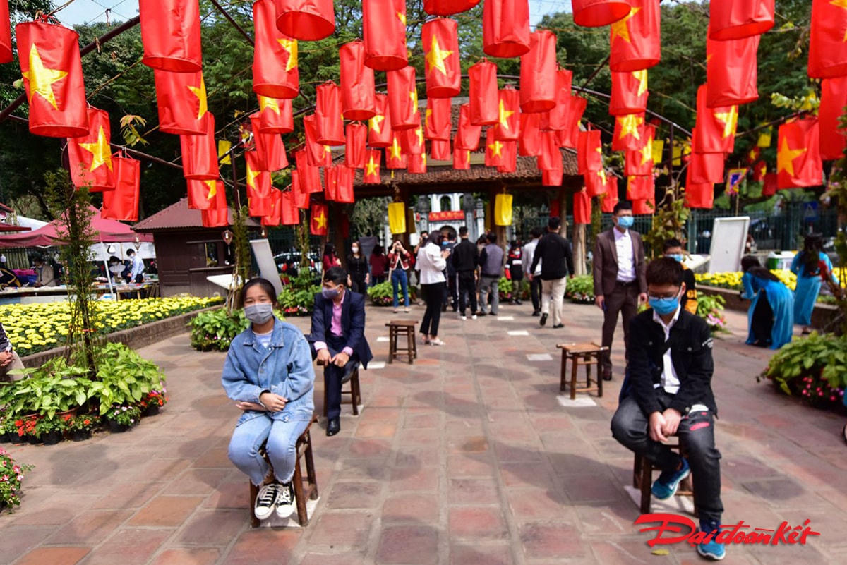 Người dân đến xin chữ ngồi xếp hàng theo quy định phòng chống dịch.
