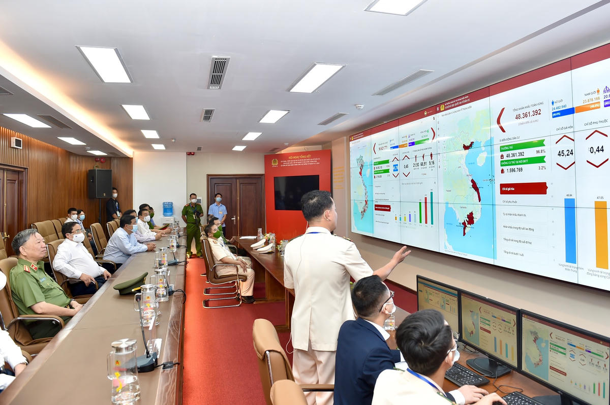 Thủ tướng Phạm Minh Chính và các đại biểu nghe giới thiệu về Hệ thống điều hành cơ sở dữ liệu dân cư. Ảnh: VGP/Nhật Bắc.