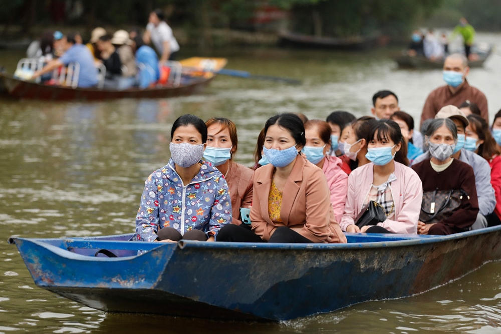 Khách thập phương đeo khẩu trang đi thuyền trên Suối Yến.