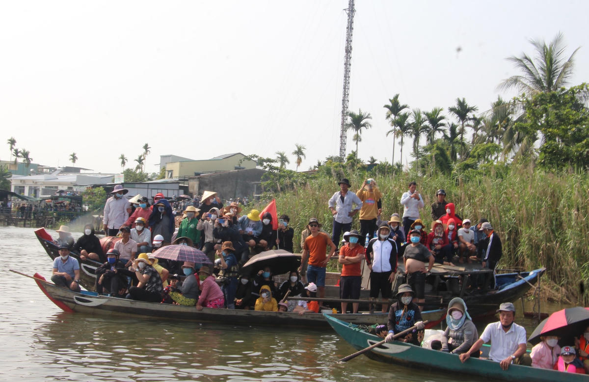 Người dân đứng trên ghe cổ vũ cho các đội đua thuyền.