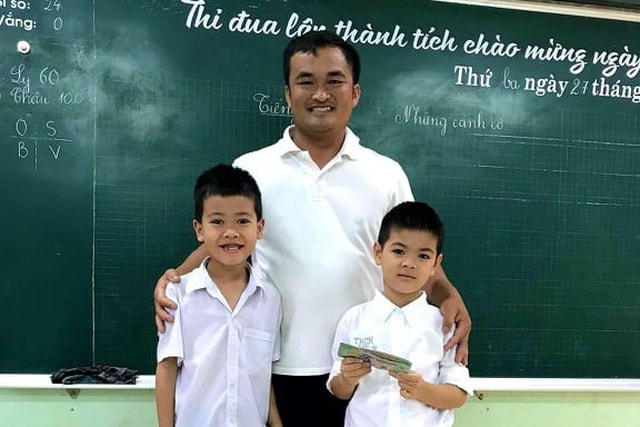 Hai em học sinh trả lại tiền cho người đánh rơi.  