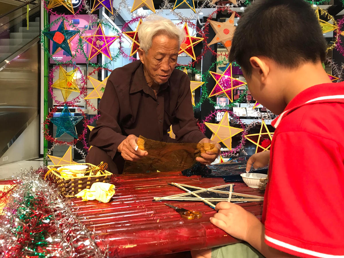 Nghệ nhân Nguyễn Văn Quyền hướng dẫn làm đèn ông sao.