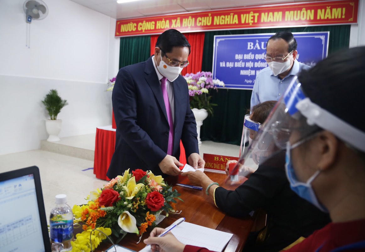 Nhân viên tổ bầu cử đóng dấu đã bỏ phiếu vào lá phiếu chứng nhận cử tri Phạm Minh Chính hoàn thành việc bỏ phiếu.