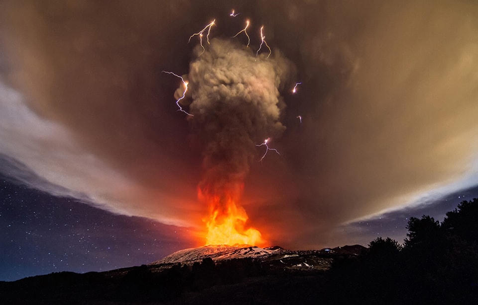 ​1. Một cơn bão ”xấu” có sấm sét núi lửa đi kèm, khi núi Etna của Italy phun trào vào ngày 3 tháng 12 năm 2015. Ảnh Marco Restivo / Demotix / Corbis.