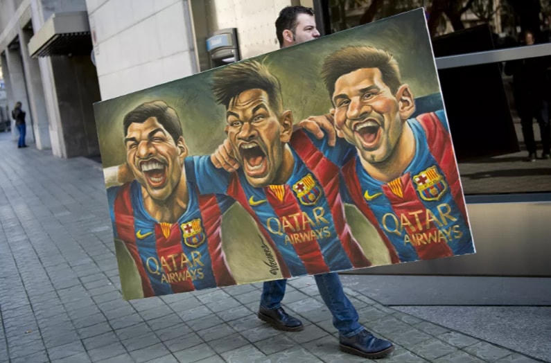 Một người đàn ông mang theo bức tranh vẽ các chân sút của Barcelona: Luis Suarez , Neymar và Messi do họa sĩ biếm họa Tây Ban Nha Vizcarra vẽ tới buổi giới thiệu ấn bản thứ 12 của cuốn sách có tựa đề "Relats solidaris de l 'esport" (Những câu chuyện về sự đoàn kết trong thể thao) tại Barcelona, ngày 17/2/2017.