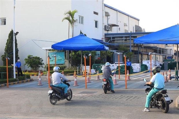 Công nhân đến làm việc tại Khu Công nghiệp Thăng Long phải đi theo làn đường đã được phân chia. (Ảnh: Phan Tuấn Anh/TTXVN).