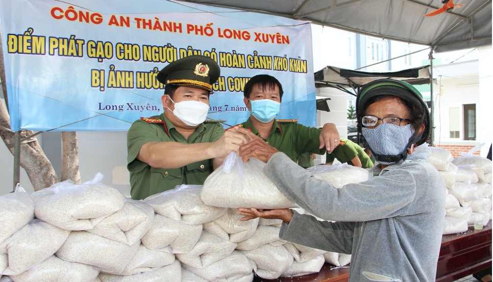 Đại tá Đinh Văn Nơi tận tay phát gạo cho người dân gặp khó khăn do ảnh hưởng của dịch bệnh Covid-19.