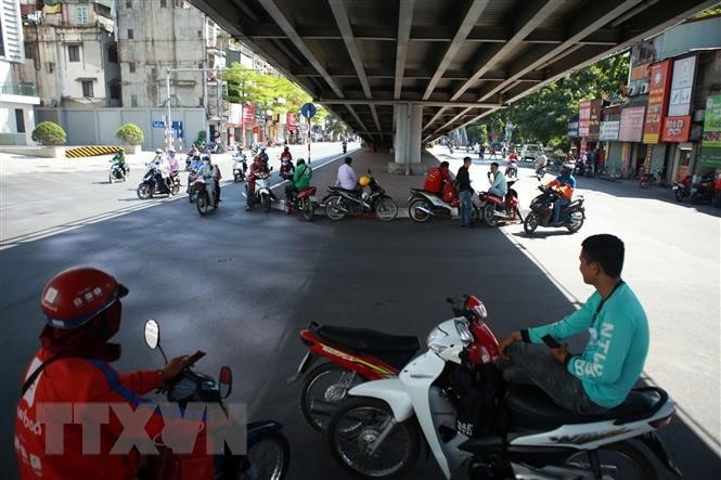 Người dân tránh nắng dưới các gầm cầu vượt tại Hà Nội. Ảnh: TTXVN.
