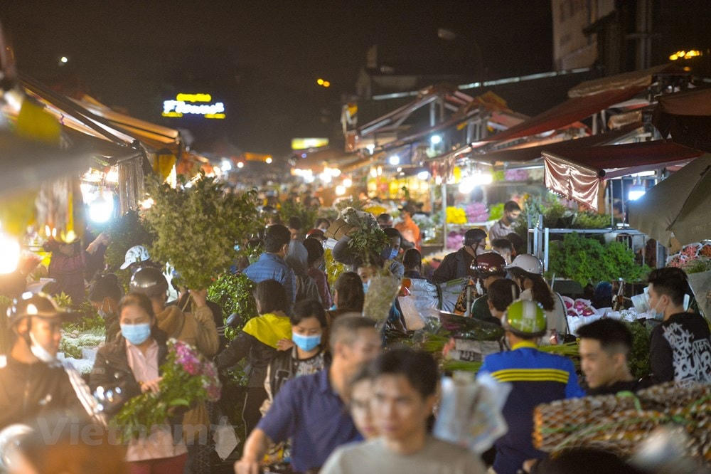 Đêm trước ngày 8/3, chợ hoa Quảng An (Hà Nội) lại càng nhộn nhịp, tấp nập cảnh kẻ bán người mua. Ảnh: Minh Sơn/Vietnam+.  