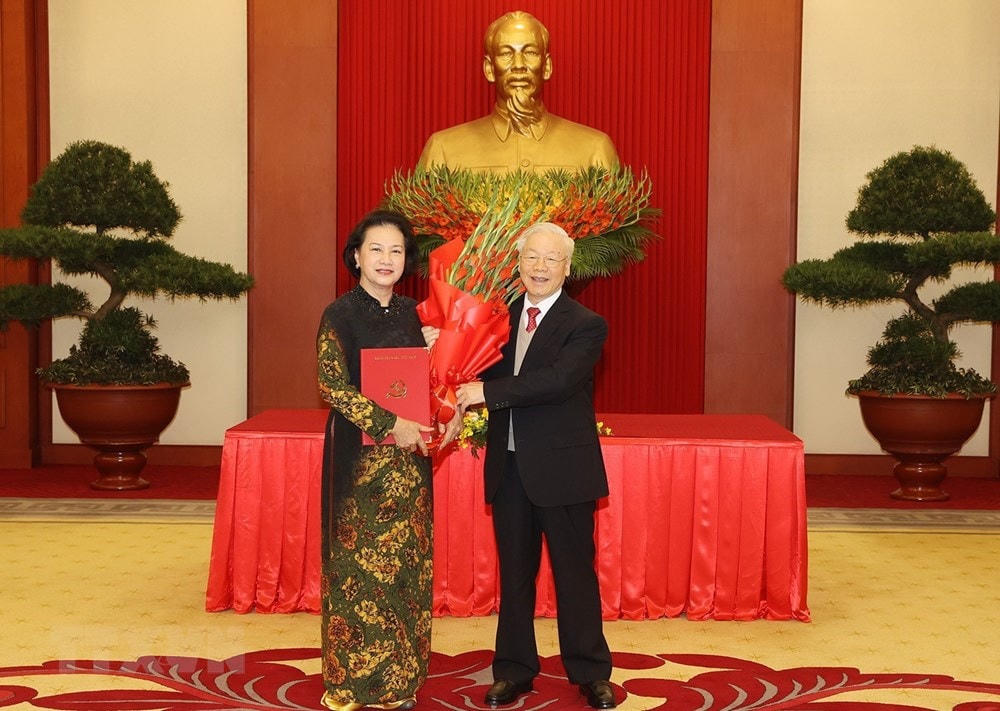 Tổng Bí thư Nguyễn Phú Trọng trao Quyết định và tặng hoa nguyên Ủy viên Bộ Chính trị, nguyên Bí thư Đảng đoàn Quốc hội, nguyên Chủ tịch Quốc hội Nguyễn Thị Kim Ngân. (Ảnh: Trí Dũng/TTXVN).