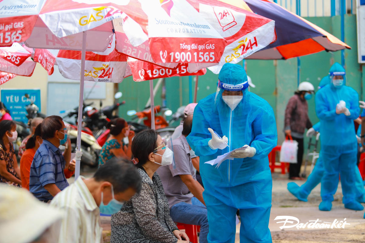 Nhân viên y tế hỗ trợ người dân điền thông tin.