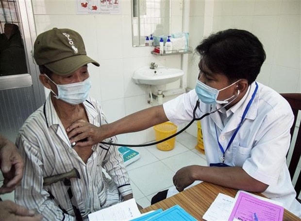 Bác sỹ Danh Ngọc Châu khám bệnh cho người dân tại Phòng khám Trung tâm Y tế huyện Châu Thành. Ảnh: Hồng Đạt/TTXVN.  