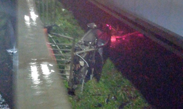 Porsche rơi xuống bãi đất trống dưới cầu Sài Gòn. (Ảnh: Huỳnh Phụng).  