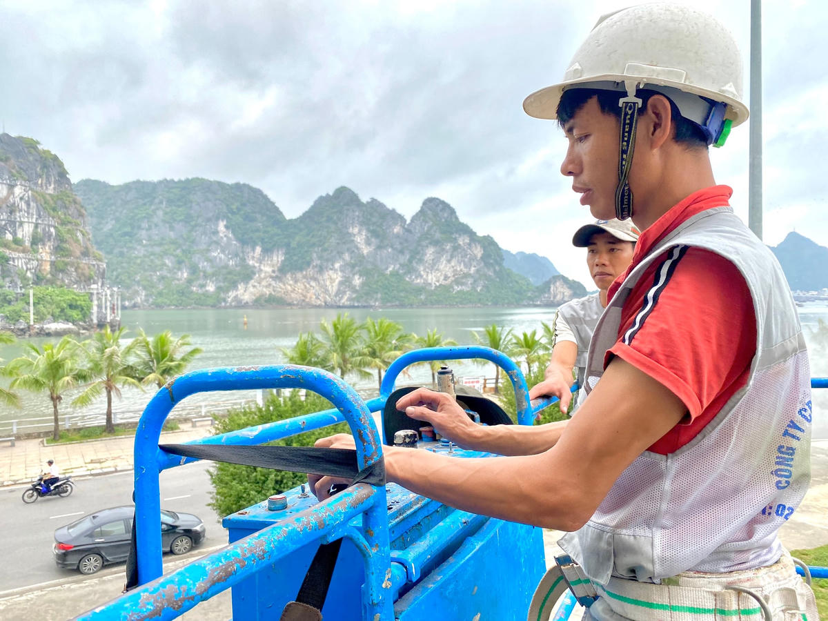 Anh Nguyễn Tiến Đắc, nhân viên giám sát kiêm thi công điều khiển xe cẩu nâng người lên cao để tiến gần đến khu vực cần vệ sinh.