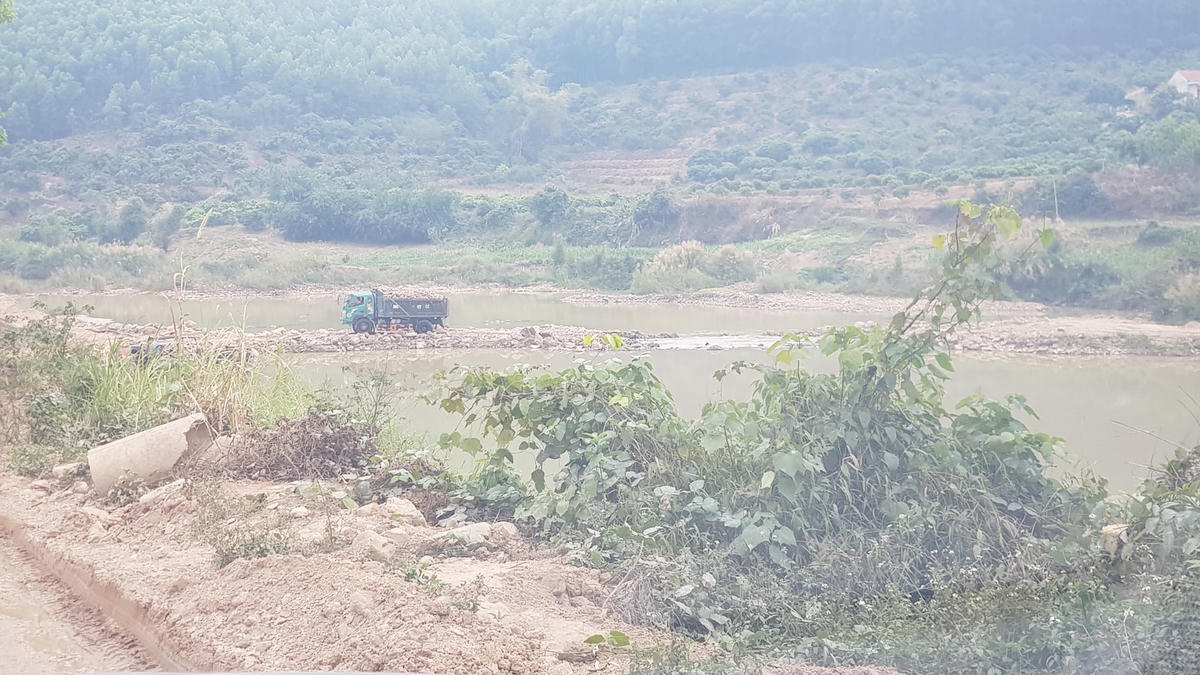 Ngang nhiên đắp đập ngăn sông để vận chuyển khoáng sản. Ảnh: Nam Anh.