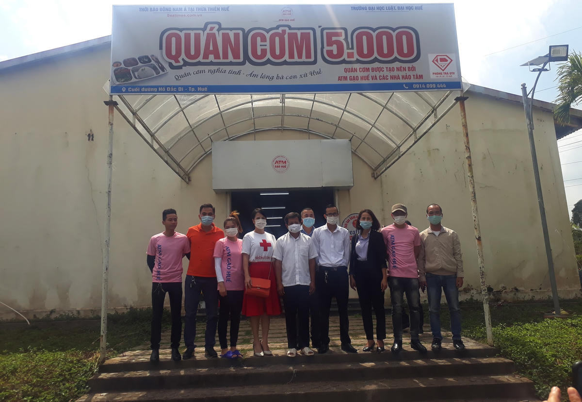 Ông Đoàn Ngọc Hải chụp ảnh lưu niệm với đại diện các thành viên thành lập quán Cơm 5000.  