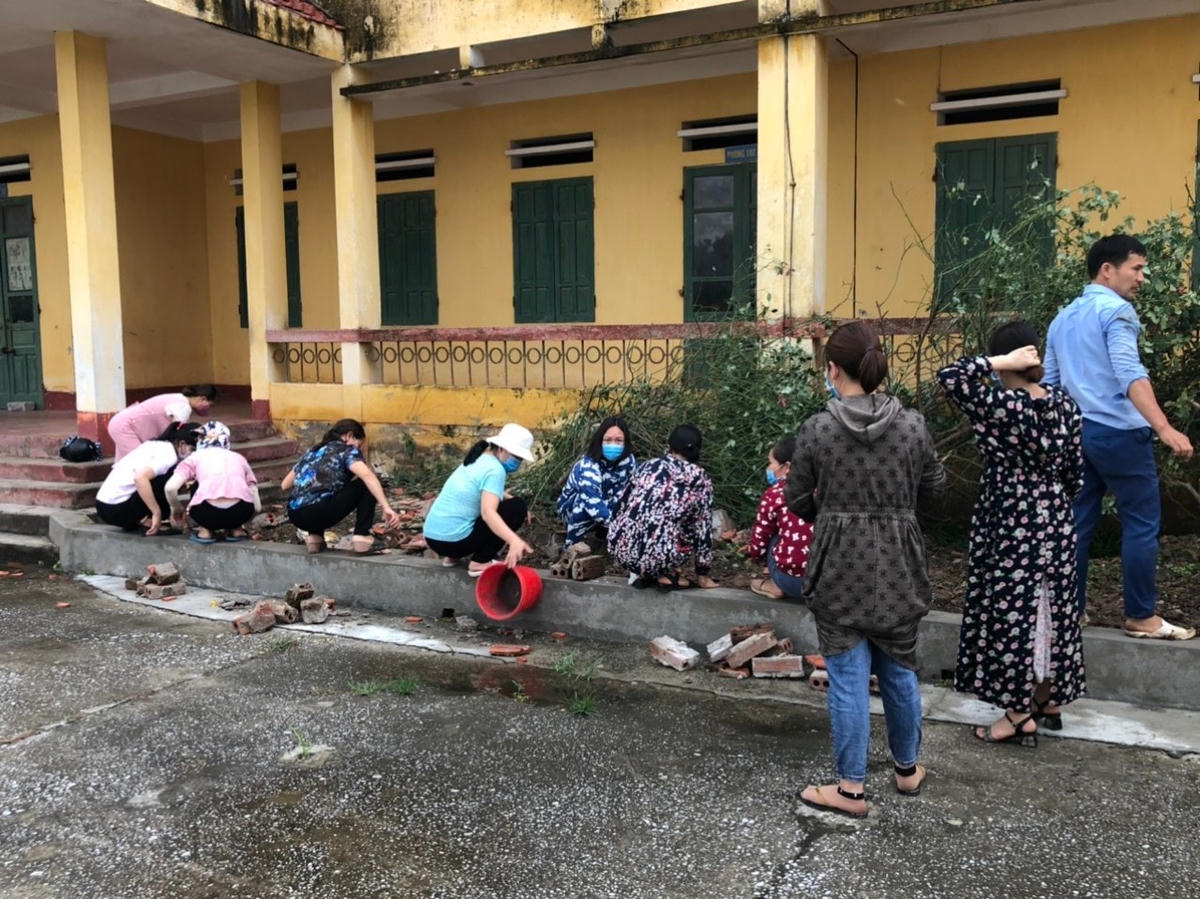 Cán bộ, giáo viên nhà trường tập trung dọn dẹp sau dông lốc. 