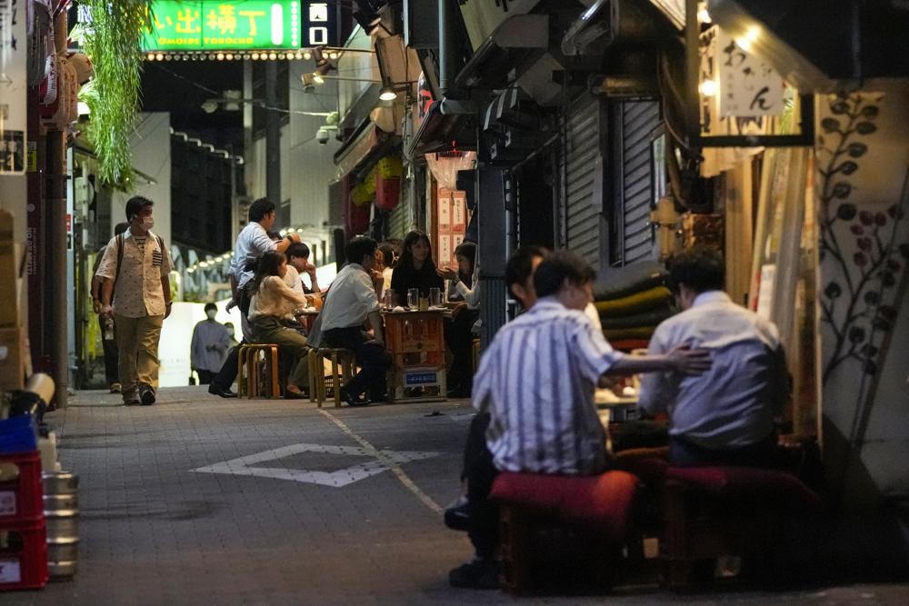 Mọi người bất chấp tụ tập tại các quán bar mở cửa và phục vụ rượu tại 1 con hẻm dù đã được chính quyền Tokyo thông báo trong tình trạng khẩn cấp. Ảnh: AP.  