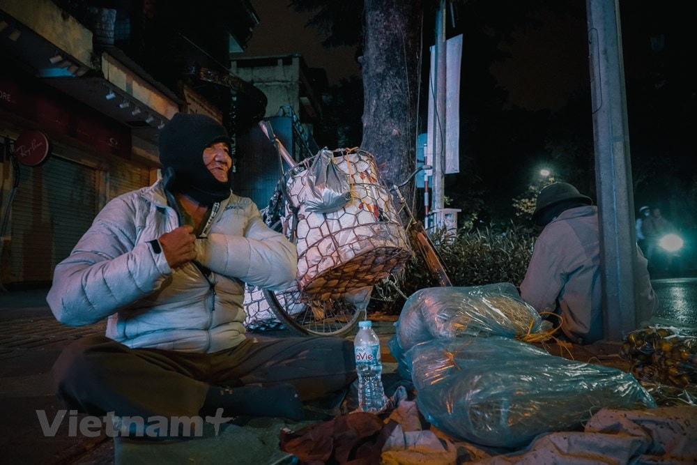 Dù đã ở độ tuổi “bát thập kế chi” (ngoài 80 tuổi) nhưng ông Nguyễn Đình Quang vẫn đang ngồi co ro trên con phố Bà Triệu để bán nốt vài túi quất, gói bánh đa để cho kịp về nhà trước khi trời trở nên rét hơn. “Làng Bình Đà (huyện Thanh Oai, Hà Nội) quê tôi từ khi cấm pháo nên giờ hết cái nghề, mấy năm nay phải lên thành phố bán ít thực phẩm để kiếm thêm chút tiền đong gạo,” ông Quang kể. (Ảnh: Minh Hiếu/Vietnam+).