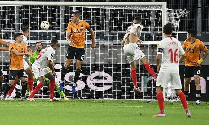 Hàng thủ Wolves (vàng) không thể đứng vững ở tình huống đánh đầu của Ocampos. Ảnh: Reuters.  