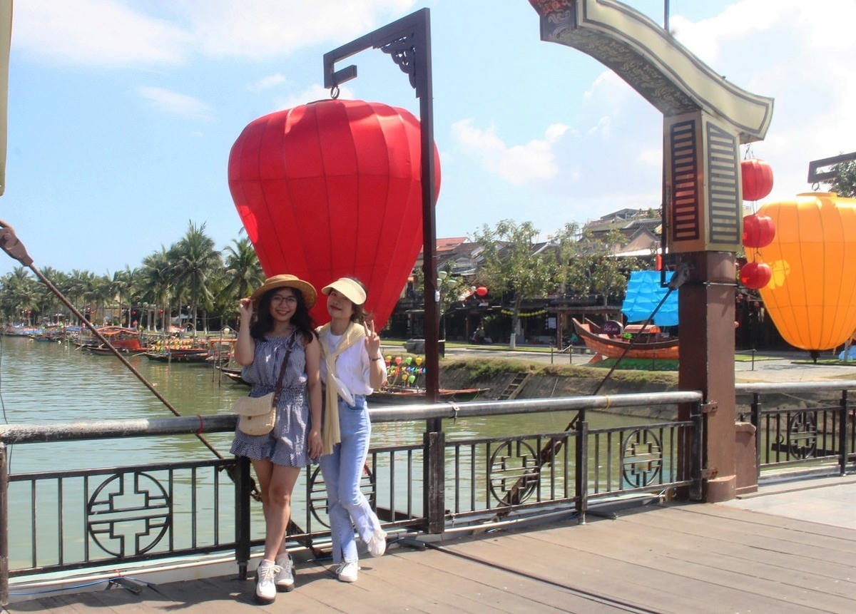Một số bạn trẻ chụp ảnh lựu niệm ở phố cổ Hội An.