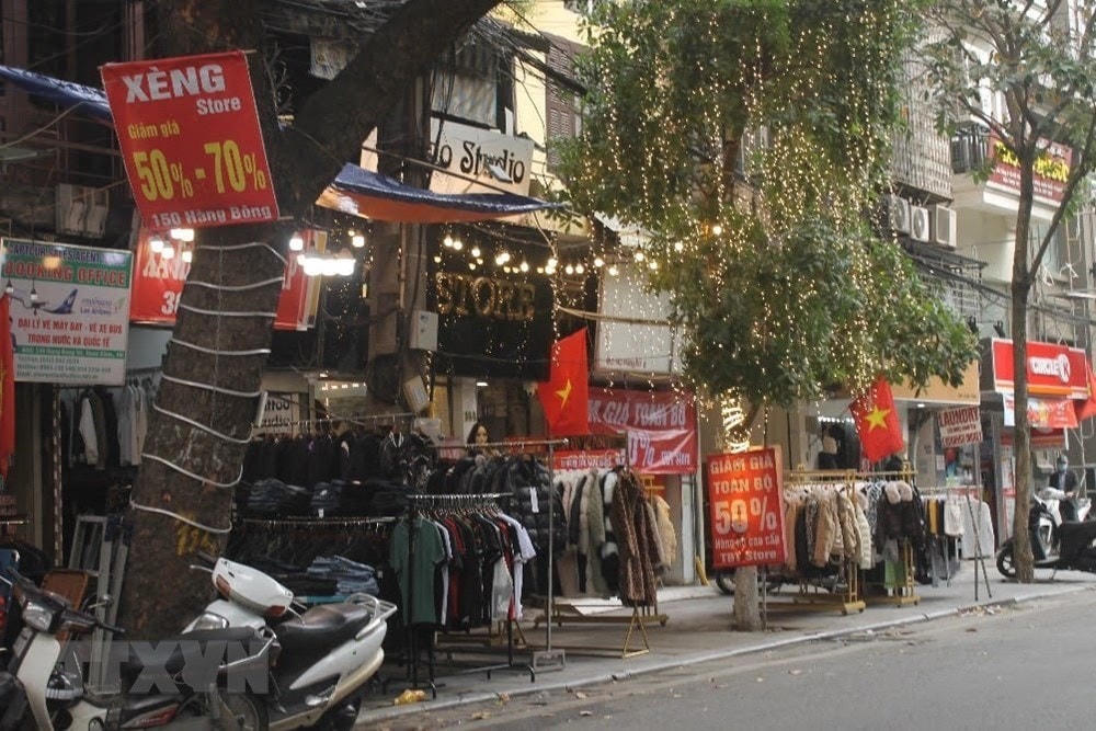 Các cửa hàng quần áo cố gắng giảm giá 'sập sàn' để thu hồi vốn trước khi đóng cửa nghỉ Tết. (Ảnh: Minh Nghĩa/TTXVN).