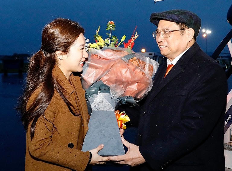 Cán bộ Đại sứ quán Việt Nam tại Vương quốc Anh tặng hoa đón mừng Thủ tướng Phạm Minh Chính đến thăm nước Anh. Ảnh: TTXVN.