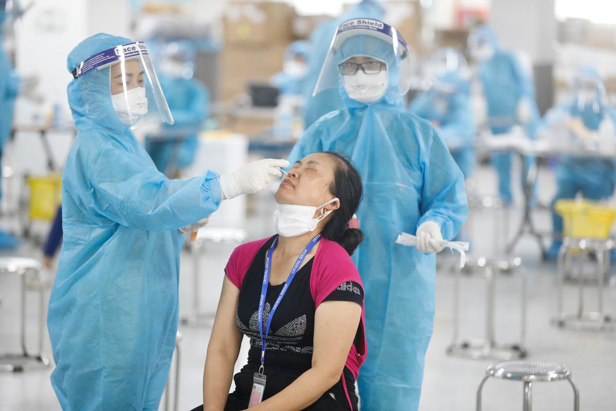 Đội ngũ y, bác sĩ Bệnh viện Việt Nam - Thụy Điển Uông Bí (Quảng Ninh) xét nghiệm Covid-19 cho công nhân Công ty TNHH Crystal Martin Việt Nam tại KCN Quang Châu, huyện Việt Yên, tỉnh Bắc Giang. Ảnh: Quang Vinh.  