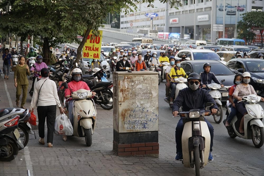 Nhiều đoạn vỉa hè khá hẹp lại bị xe máy leo kín khiến người đi bộ phải chuyển hướng đi xuống sát lòng đường. Anh Hoàng Nam (phường Phương Liệt, quận Thanh Xuân) cho biết tình trạng ùn tắc nghiêm trọng hơn từ khi đường Trường Chinh hoàn thành việc mở rộng. (Ảnh: Minh Hiếu/Vietnam+).