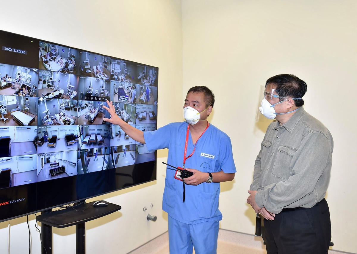 PGS.TS Nguyễn Lân Hiếu, Giám đốc Bệnh viện Đại học Y Hà Nội phụ trách Bệnh viện dã chiến điều trị Covid-19 tại Bệnh viện quốc tế Becamex giới thiệu với Thủ tướng hoạt động điều trị chung của Bệnh viện dã chiến qua hệ thống giám sát trung tâm.