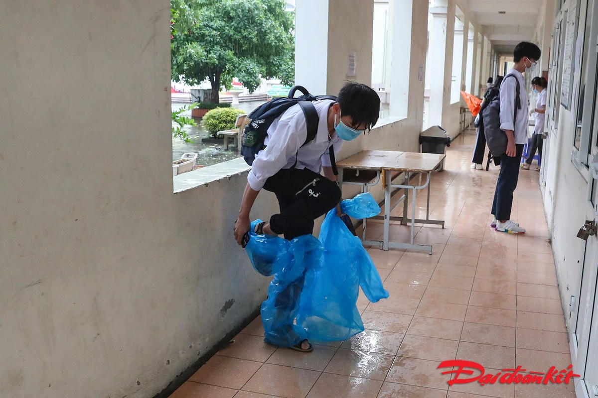 Nhiều em thí sinh mặc áo mưa vào tận trong khu vực hành lang phòng thi. Ảnh: Quang Vinh.