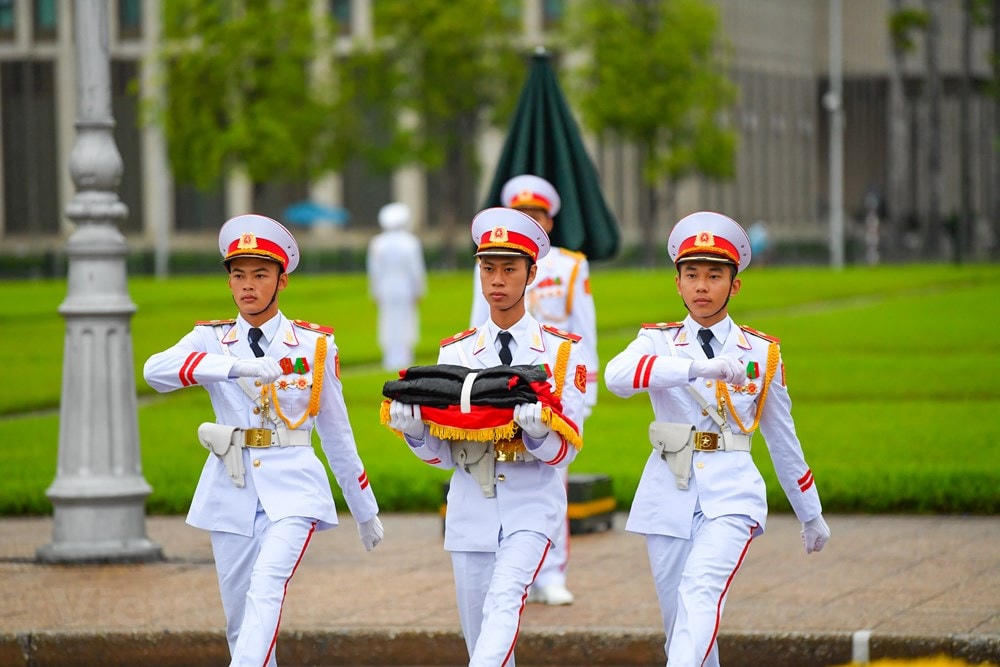 Nghi lễ treo băng tang được tiến hành song song với nghi thức chào cờ hàng ngày vẫn diễn ra trên Quảng trường Ba Đình. (Ảnh: Minh Sơn/Vietnam+).