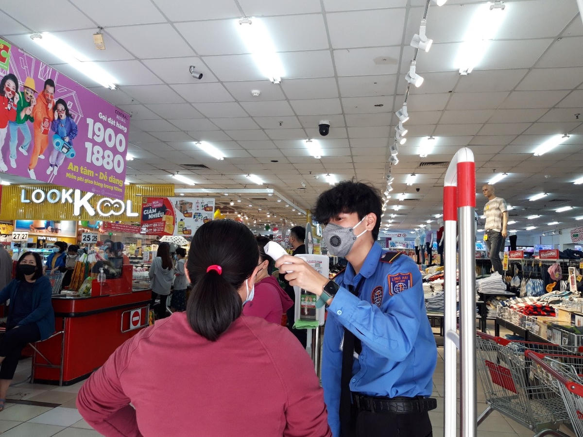 Siêu thị tăng cường phòng dịch bằng cách kiểm tra thân nhiệt, yêu cầu khách giữ khoảng cách an toàn và đeo khẩu trang.