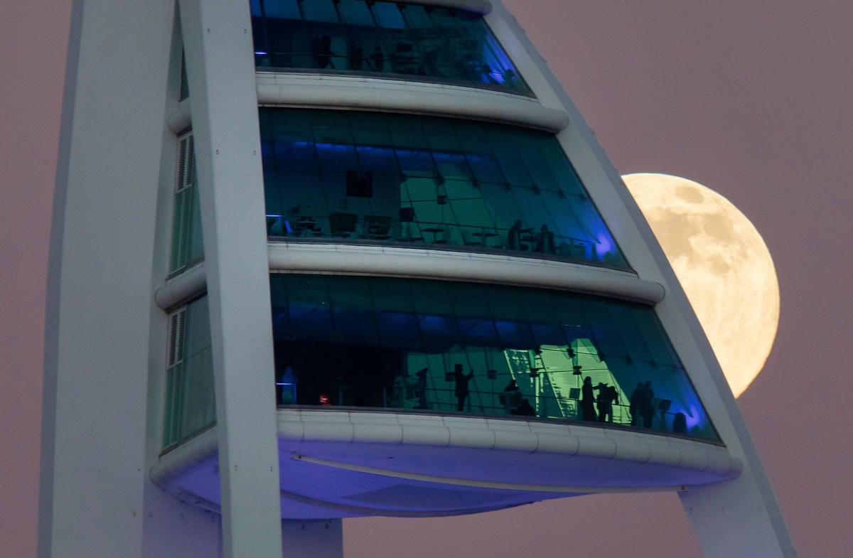 Hình ảnh Trăng tròn đầu tiên của năm 2022 hé rạng sau tháp Spinnaker ở Portsmouth, Anh. Ảnh: James Marsh / REX / Shutterstock.