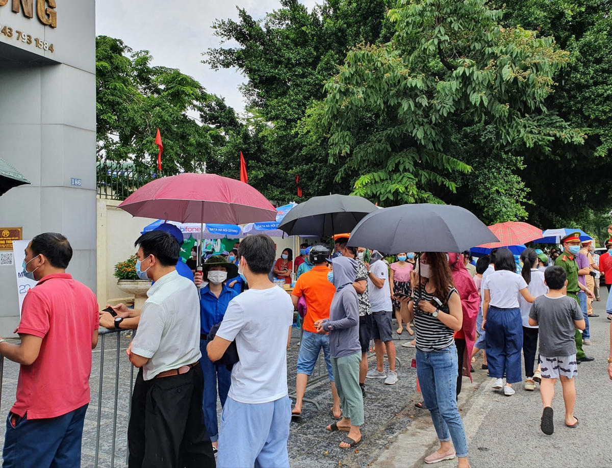 Đến khoảng 11h30 trời bắt đầu đổ mưa, nhiều phụ huynh cầm ô tập trung trước cổng trường để đợi con.