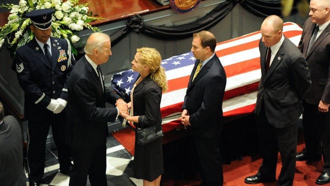 Joe Biden nắm tay khách đến đưa tiễn con trai ông, Beau Biden, trong đám tang năm 2015. (Ảnh: USA Today).