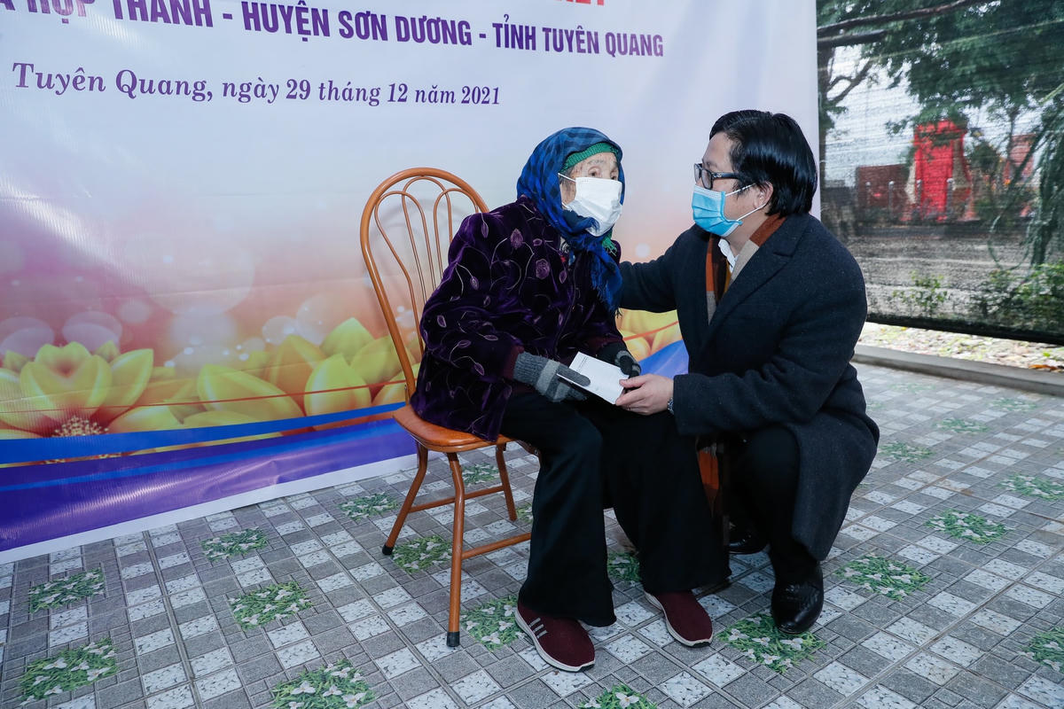 Quyền Tổng Biên tập Lê Anh Đạt thăm hỏi, tặng quà cụ Nông Thị Chí. Ảnh: Quang Vinh.