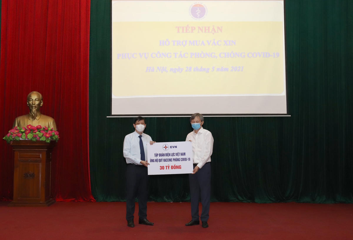 Bộ trưởng Bộ Y tế Nguyễn Thanh Long (bên trái) đón nhận biểu trưng tài trợ Quỹ vaccine phòng Covid-19 của EVN.