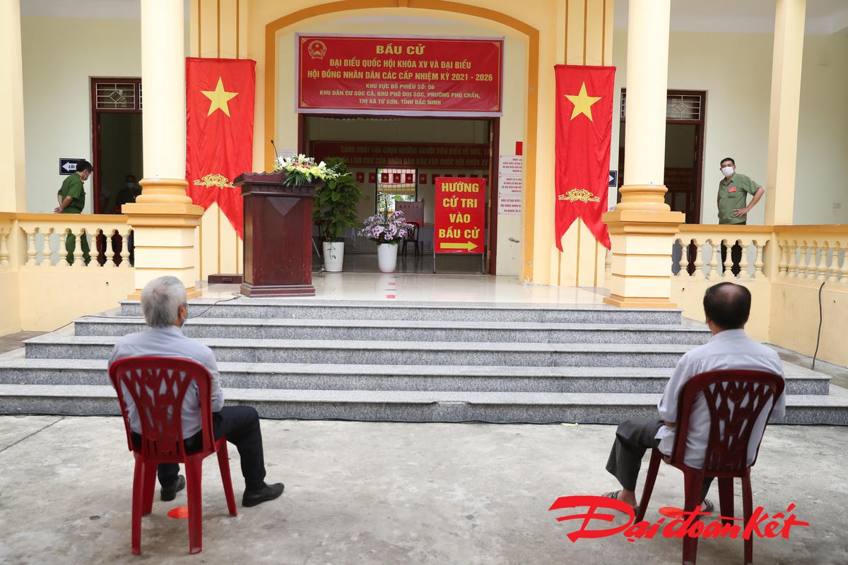 Sau khi hoàn thành các thủ tục, cử tri đi vào phía trong để bỏ phiếu bầu cử. Các cử tri xếp hàng, số lượng cử tri vào bầu cử được kiểm soát chặt chẽ. Ảnh: Quang Vinh. 