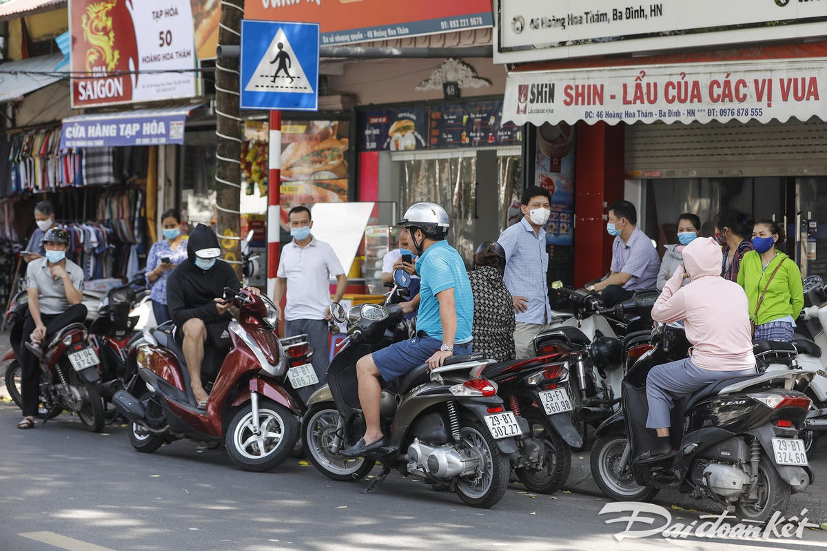 Trước giờ kết thúc môn thi đầu tiên, các phụ huynh đã đứng xếp hàng dài chờ đón con. Ảnh: Quang Vinh. 