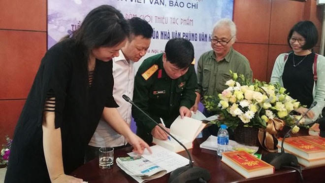 Nhà văn Phùng Văn Khai ký tặng độc giả trong một buổi ra mắt sách.