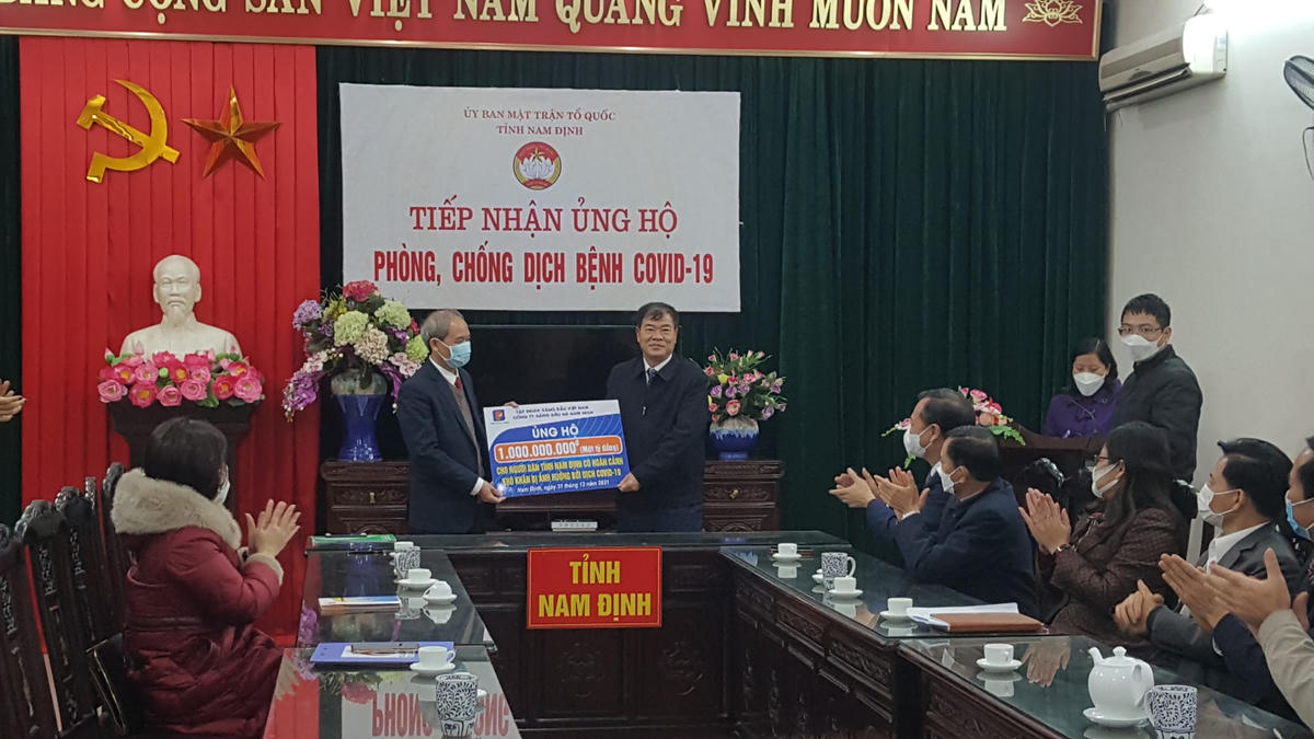 Chủ tịch Ủy ban MTTQ Việt Nam tỉnh Nam Định Đoàn Văn Hùng (trái) tiếp nhận tiền ủng hộ từ đại diện Công ty Xăng dầu Hà Nam Ninh.
