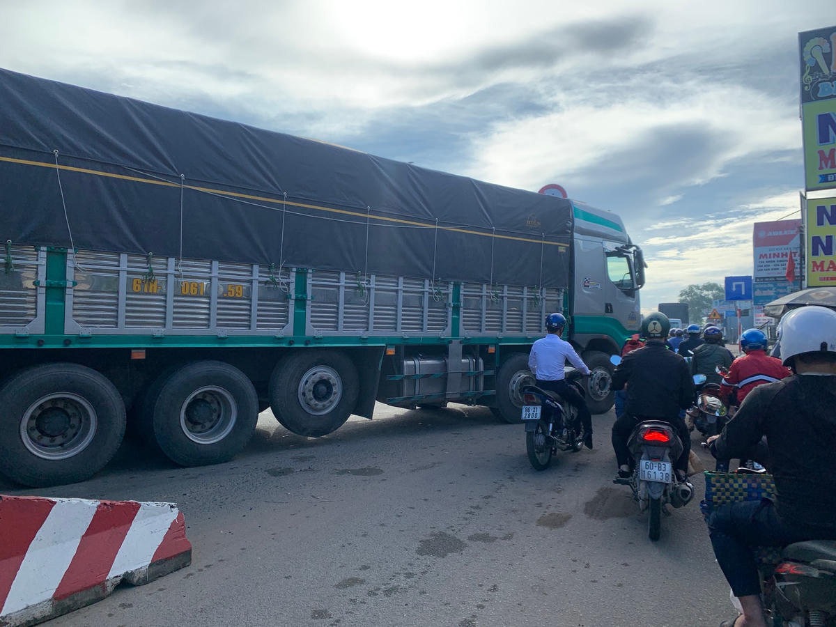 Một chiếc xe tải lớn đang cố chen vào làn dành cho xe máy khi thấy kẹt xe.