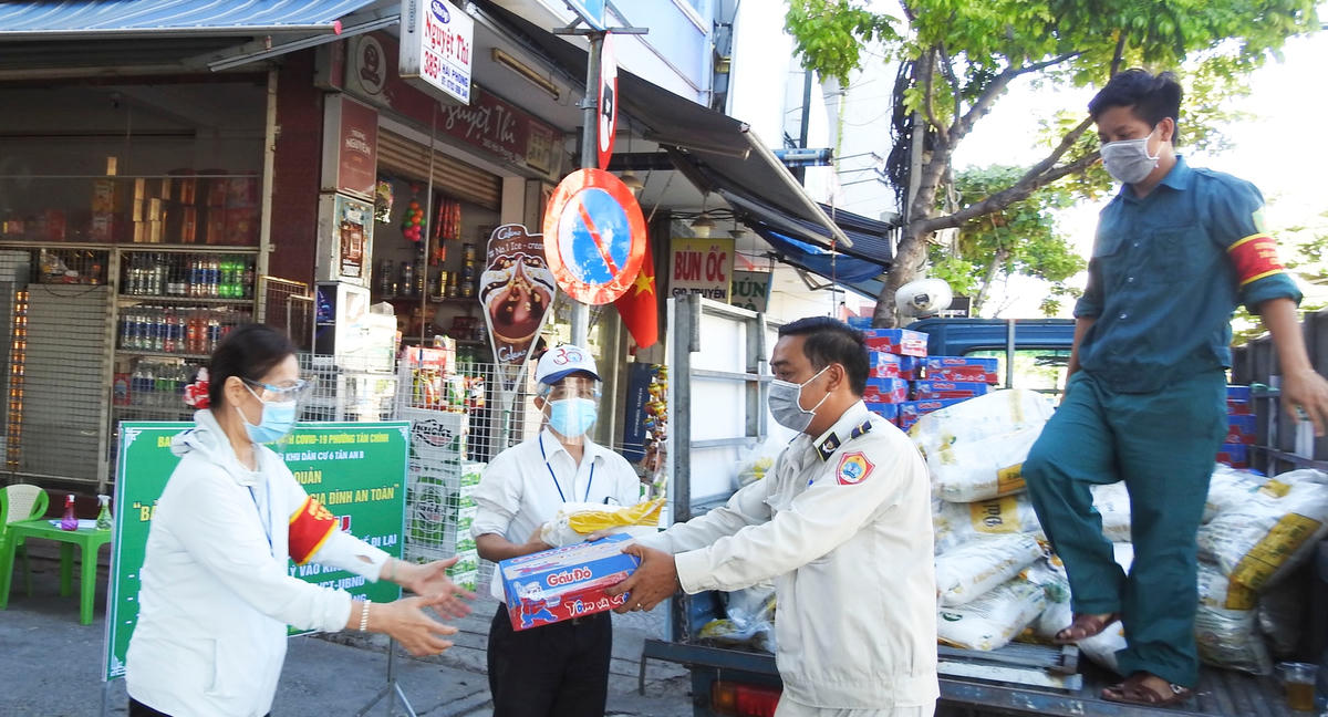 Lực lượng phòng, chống dịch quận Thanh Khê, trao lương thực, thực phẩm hỗ trợ các hoàn cảnh khó khăn của phường Tân Chính. Ảnh Thanh Tùng