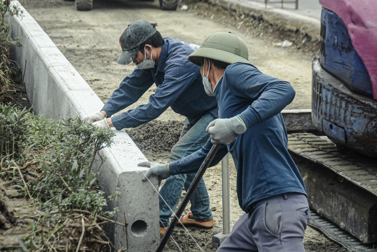 Các công nhân đang gấp rút thi công phần bó vỉa phân cách.