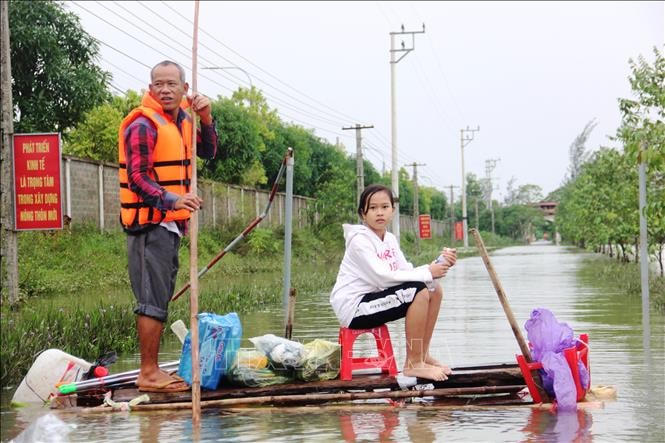 Người dân vùng lũ cần được bảo đảm sinh kế lâu dài. Trong ảnh: Hai cha con ở thôn Bình Tiến (xã Tân Lâm Hương, huyện Thạch Hà, tỉnh Hà Tĩnh) trong mùa lũ vừa qua. Ảnh: BTT.