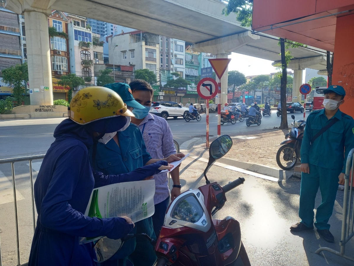Lực lượng chức năng kiểm tra giấy tờ của người dân tại chốt kiếm soát ngõ 199 Hồ Tùng Mậu. 